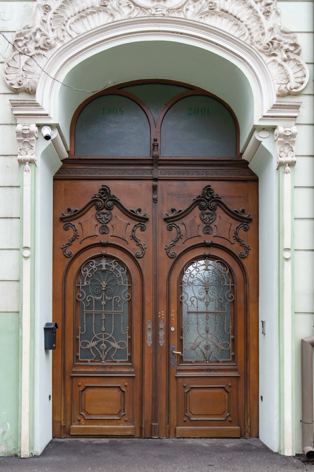 Carved double wood entry doors with arched glass lites