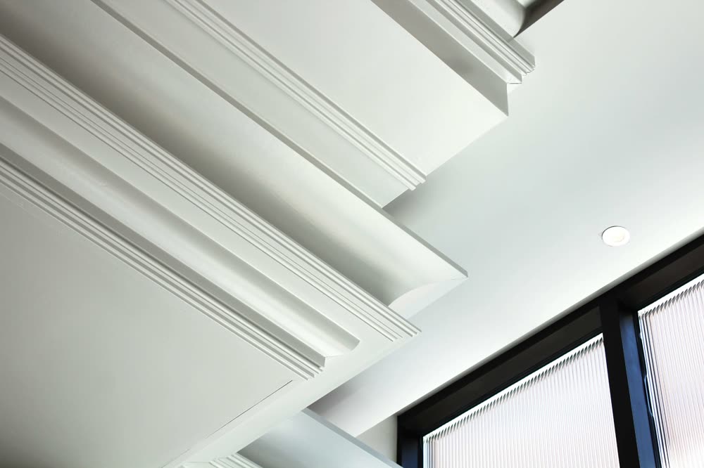 Layered white crown molding where wall meets ceiling