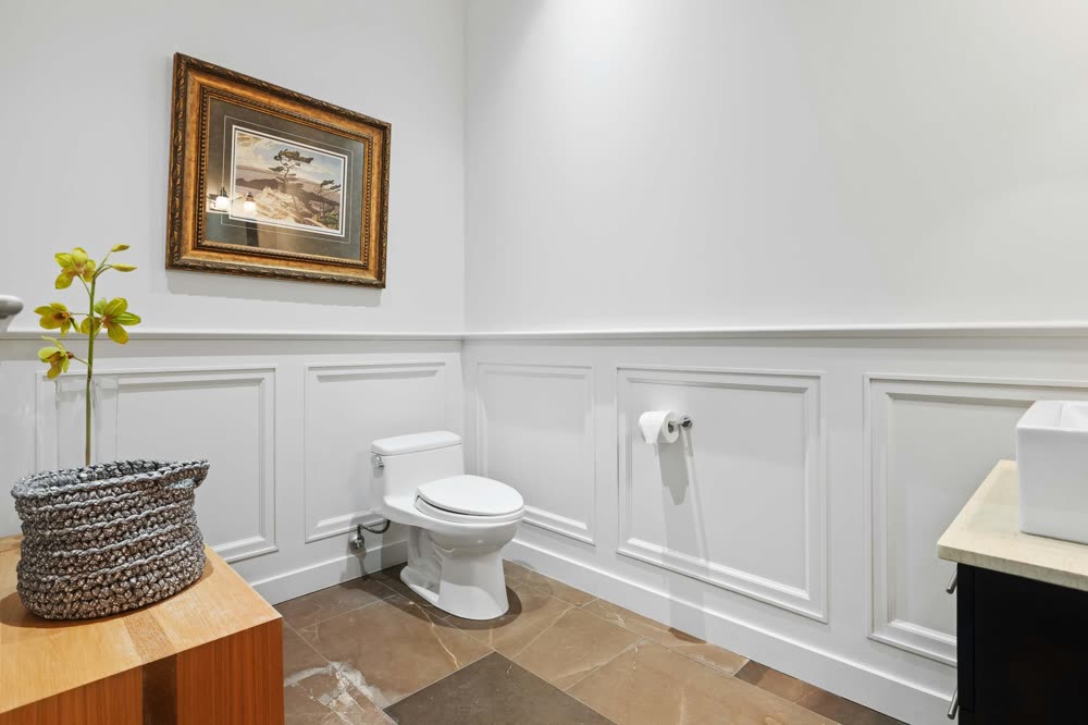 White wainscoting panels on the lower wall of a bathroom